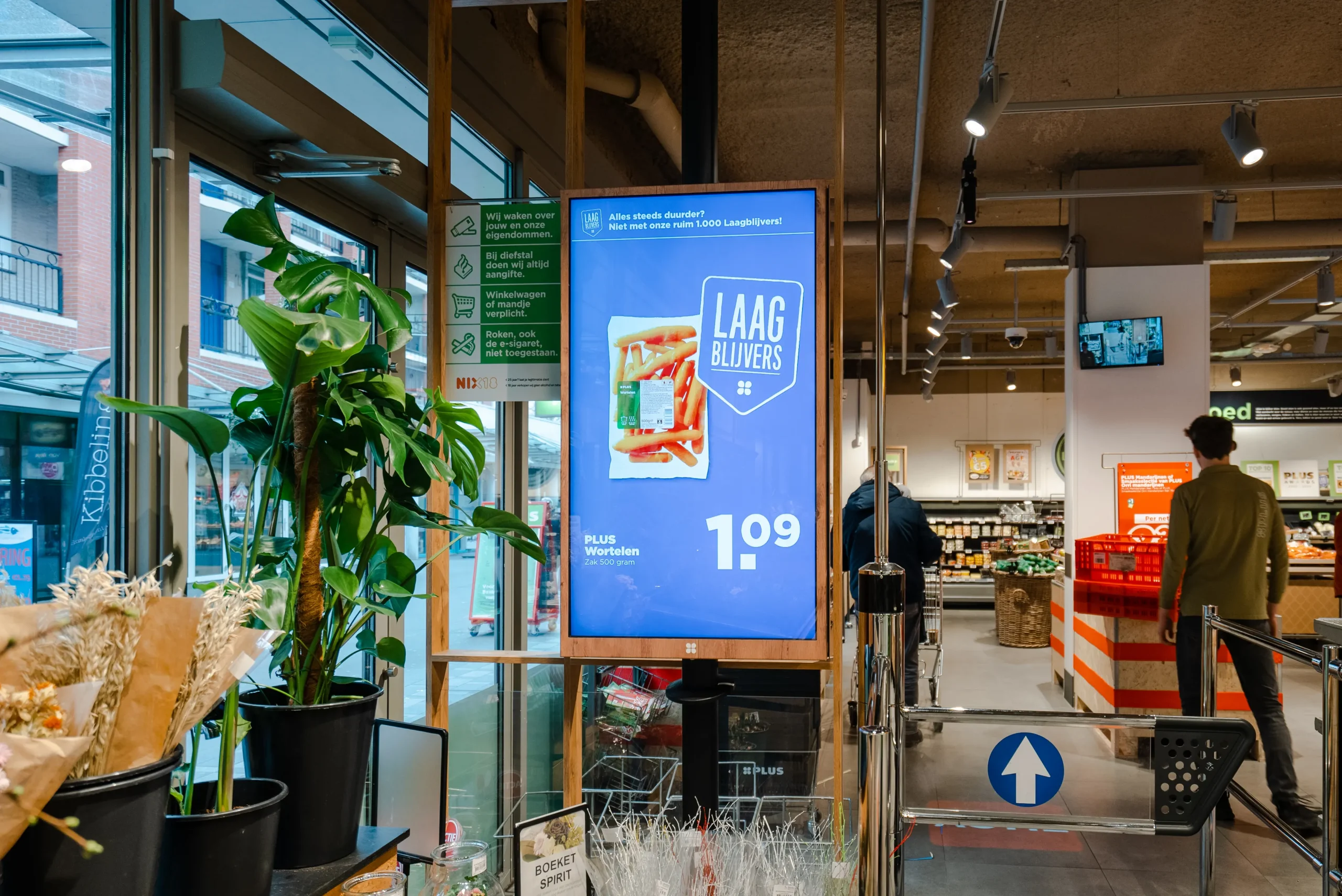 Verticale narrowcasting reclamescherm binnen PLUS supermarkt